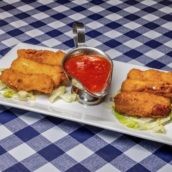 Golden-brown fried mozzarella sticks with a side of red marinara sauce on a white plate.